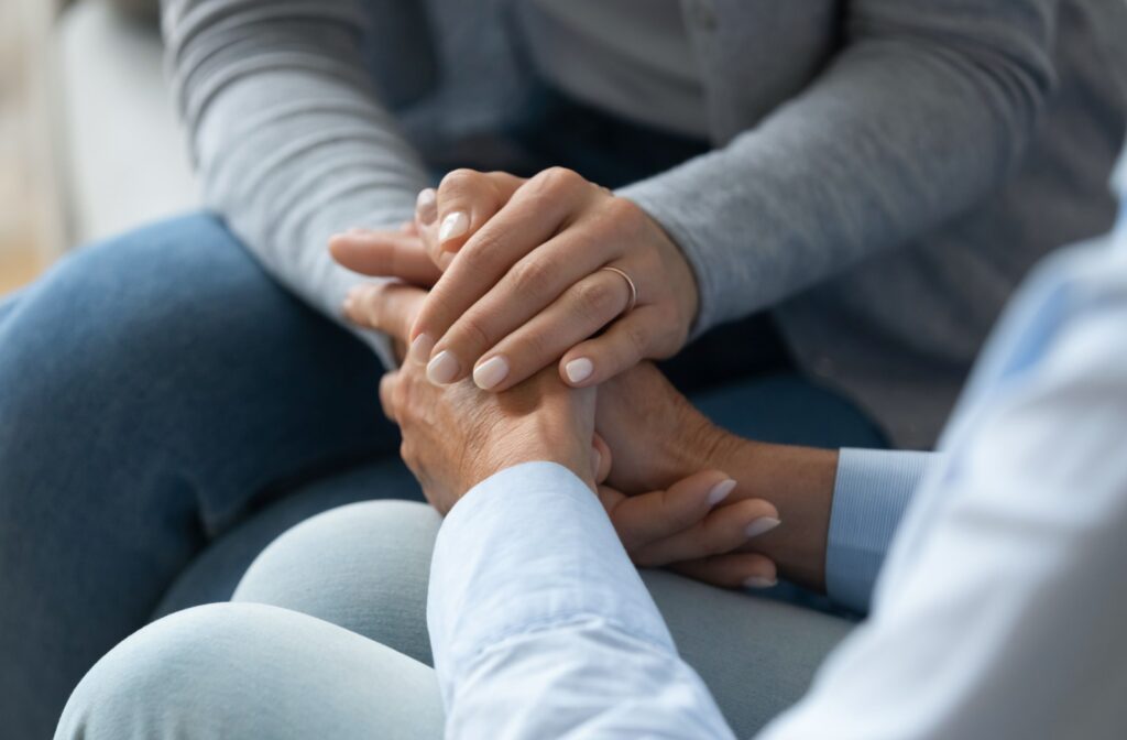 An adult child comforting their older parent during a conversation about assisted living.
